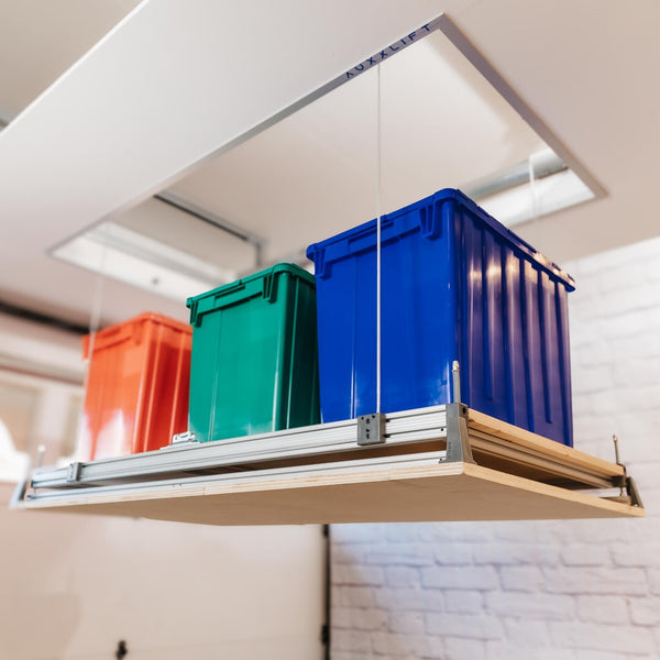 Auxx Attic-Lift platform lowered from the ceiling opening carrying three storage totes