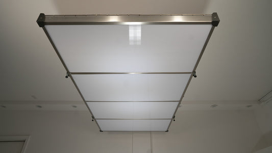 Auxx-Lift platform fitted with the Auxx-Cover underside panels, seen from below as a clean white ceiling panel