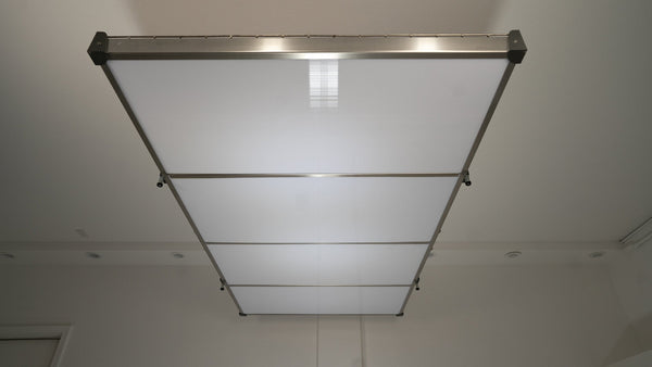 Auxx-Lift platform fitted with the Auxx-Cover underside panels, seen from below as a clean white ceiling panel