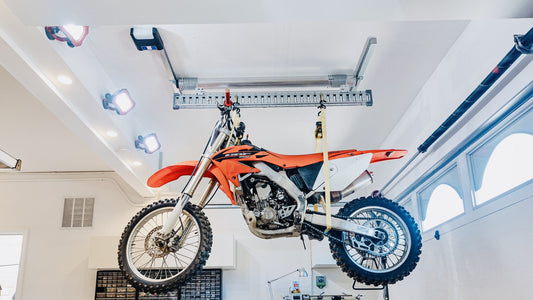 Dirt bike hoisted to the garage ceiling on an Auxx-One motorized lifting beam